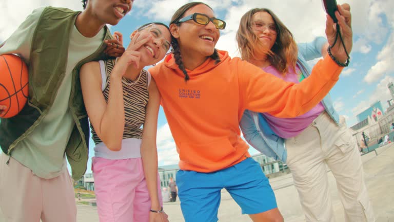 Wide angle shot of Gen Z group of friends using a smartphone together.