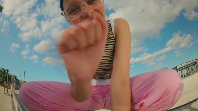 Wide angle shot of a teenager using smartphone at school or skate park.
