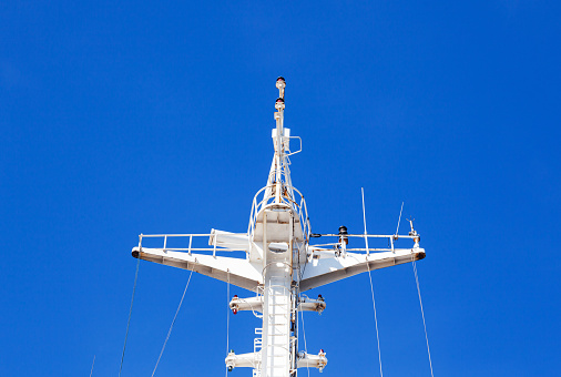 Mast of a cargo ship with navigation equipment bottom view. Radar, signal beeps and signal lights.