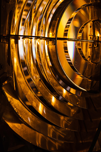 Close up vertical photo of a lighthouse lamp with Fresnel lens. It is a type of composite compact lens developed by the French physicist Augustin-Jean Fresnel for use in lighthouses