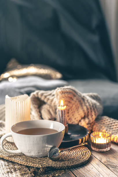 istock Cozy home composition with a cup of tea, candles and a knitted element. 1923543507