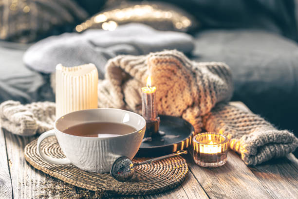 istock Cozy home composition with a cup of tea, candles and a knitted element. 1923543965