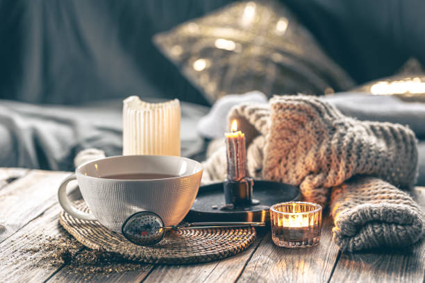 istock Cozy home composition with a cup of tea, candles and a knitted element. 1923544026