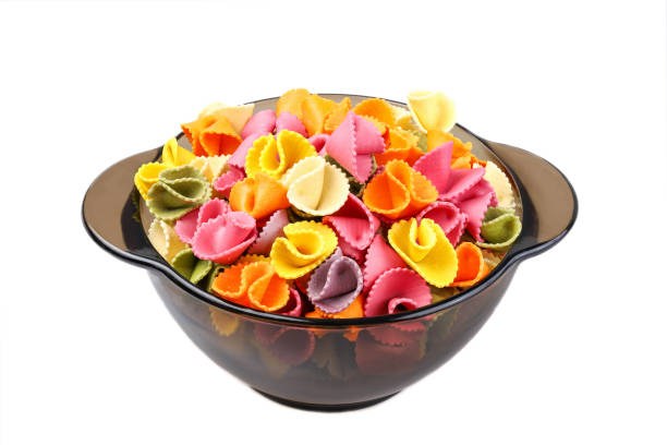 Colored pasta in a bowl, isolated on a white background