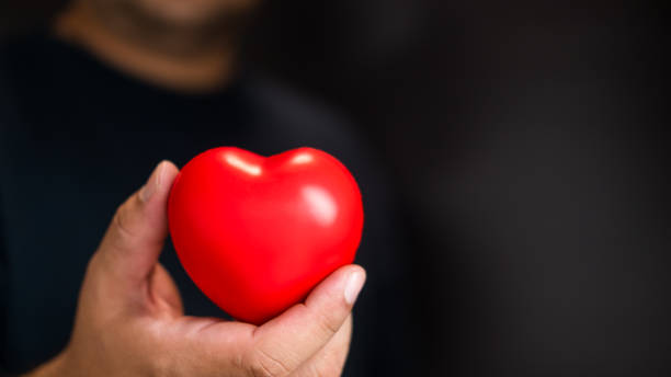 istock Man hand give red heart for love 1923611493