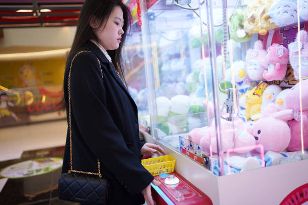 istock Young woman playing with doll machine 1923628859