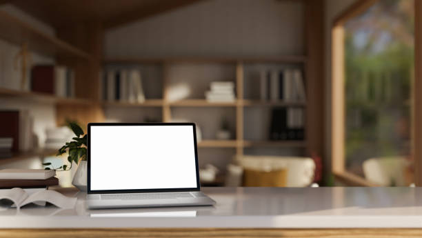 istock A modern, Scandinavian home workspace with a white-screen laptop computer mockup on a white desk. 1923633609
