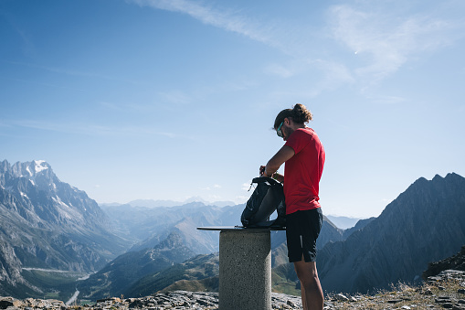 Trail runner pauses on mountain pass, tour of Mont Blanc