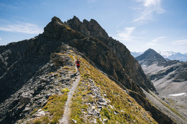 Trail runner bounds along mountain trail