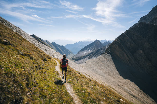 istock Trail runner bounds along mountain trail 1923644696