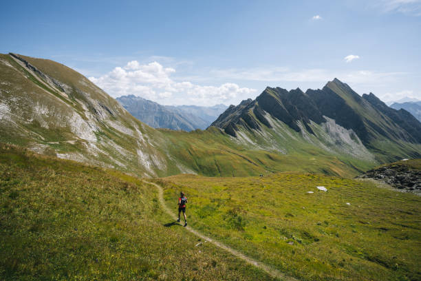 istock Trail runner bounds along mountain trail 1923649413