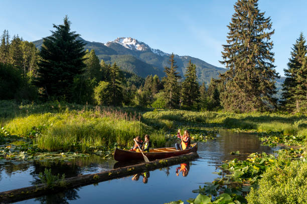 Family paddles canoe down stream