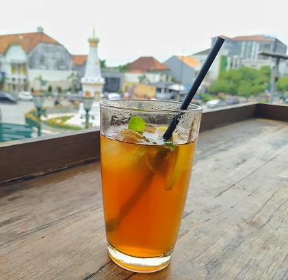 Lemon iced tea drink with the Yogyakarta monument in the background
