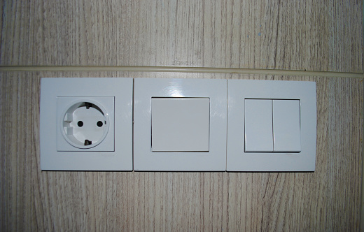 Electric plug in and light switch on the bed room wall.