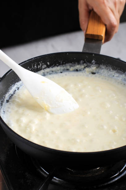 istock Boiling White Bechamel Sauce in Black Pan, Cooking Process Making Pasta Bechamel Sauce in the Kitchen. Selected Focus 1923779964