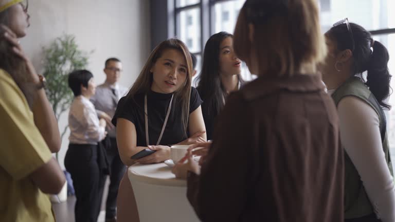 Asian young professionals having a casual chat after successful conference event