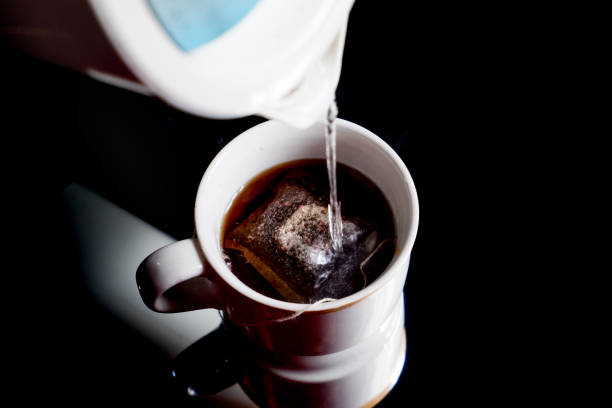 istock pouring hot water into the tea cup, making hot tea on the table 1923871510
