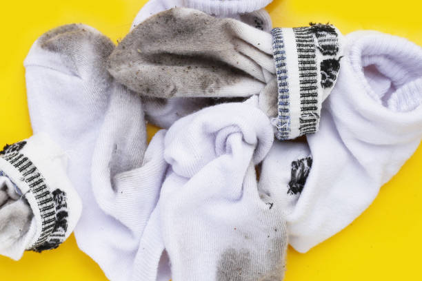 istock Dirty white socks on yellow background. 1923876814