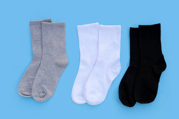 istock Grey, white and black socks on blue background. 1923897500