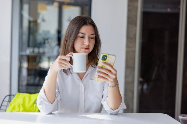 istock Young businesswoman talking on phone and drinking coffee during break . 1923900089