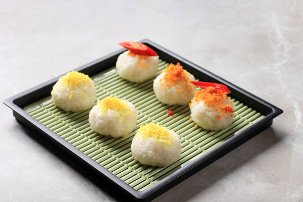 Ketan Serundeng is Indonesian Snack Made  from Sticky Rice Ball with Coconut Floss/Grated Coconut Floss. Served on Japan Plate with Tea