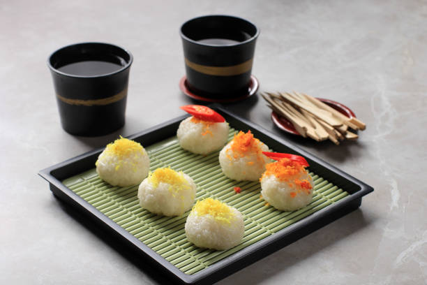Ketan Serundeng is Indonesian Snack Made  from Sticky Rice Ball with Coconut Floss/Grated Coconut Floss. Served on Japan Plate with Tea