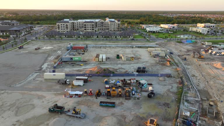 Construction site with building equipment on prepared ground in American suburbs. Aerial view of large development area of residential housing