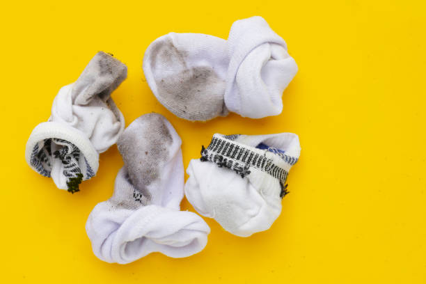 istock Dirty white socks on yellow background. 1923928168