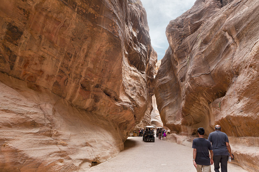 Wadi Musa, Jordan, October 05, 2023 : Tourists walk and look at sights of gorge Al Siq in the Petra in Wadi Musa city in Jordan