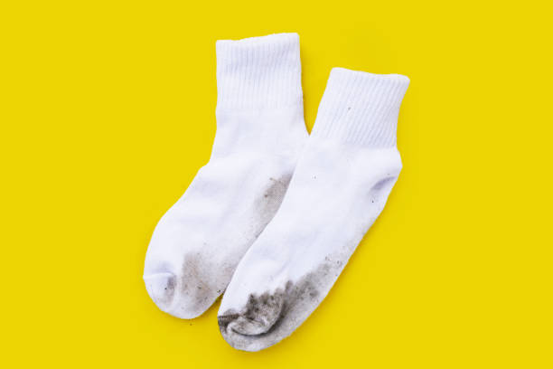 istock Dirty white socks on yellow background. 1923945809