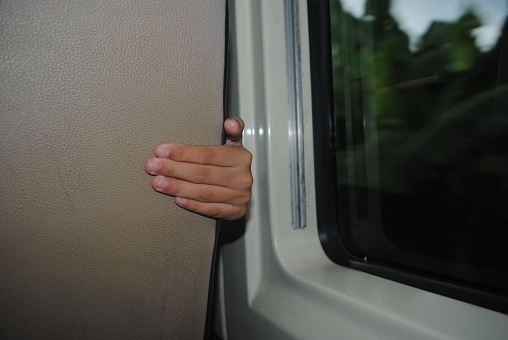 A hand appears in passenger seat inside the running train.