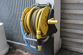 A yellow garden hose reels.