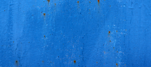 Abstract cracked and scracthed iron rusty wall with blue dry paint