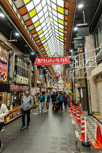 2023-11-11 Osaka, Japan. People walking in a covered shopping street in Osaka, Japan