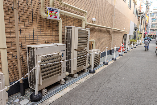 2023-11-11 Osaka, Japan. Panasonic air conditioners on the brick wall of a building in Osaka, Japan