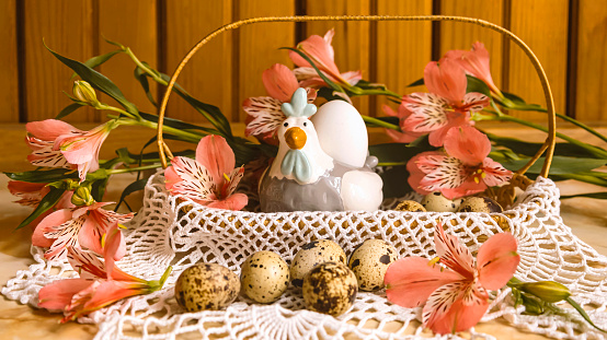 Easter basket with quail eggs decorative chicken with egg peach fuzz alstroemeria flowers