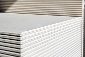 The stack of WHITE drywall Standard Gypsum board panel. Plasterboard. Panel Type A designed for indoor walls, partitions and ceilings, construction site
