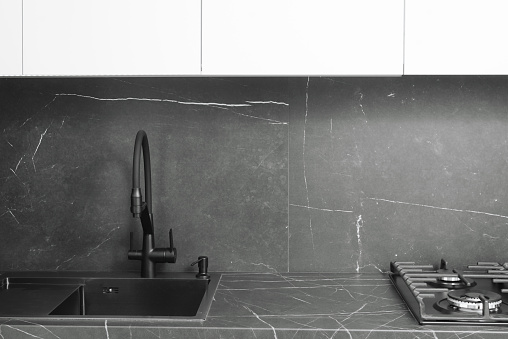 Black modern minimalist kitchen interior. Sink, countertop and faucet.