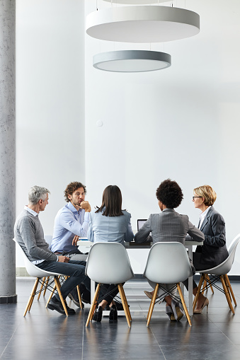 Group of entrepreneurs talking while having a business meeting in a modern office. Copy space.