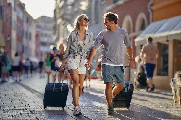 istock Happy couple talking while pulling their luggage on the city street. 1924148159