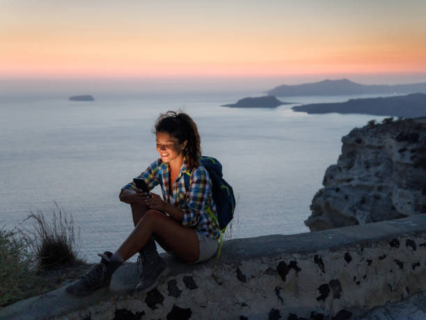 istock Happy female hiker using cell phone at sunset. 1924162618