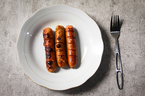 a plate of sausages with a fork on the table