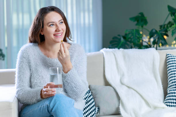 istock Young woman taking Omega 3 capsule 1924224471