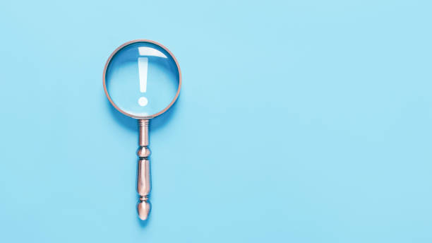istock magnifying glass shows an icon exclamation mark on a blue background 1924230704