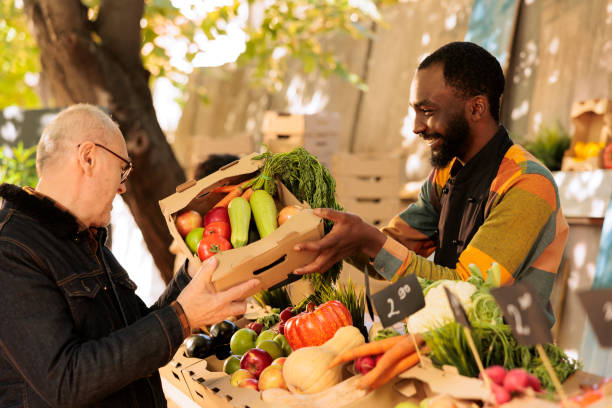 istock Smiling vendor offers food items to client 1924266506