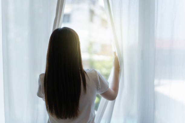 istock Woman open curtain. 1924279303