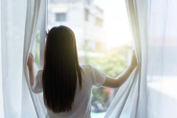istock Woman open curtain. 1924279819