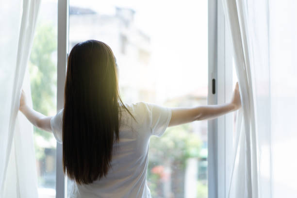 istock Woman open curtain. 1924279820