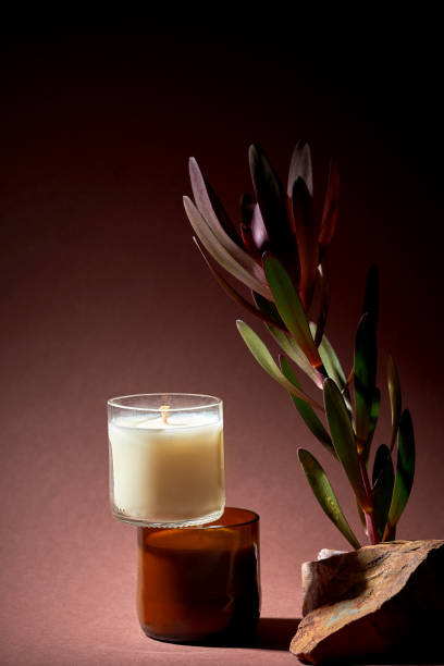 istock Creative minimalist composition with candles with stones, branches on a brown background. Mockup for candle makers. Aesthetics 1924318415