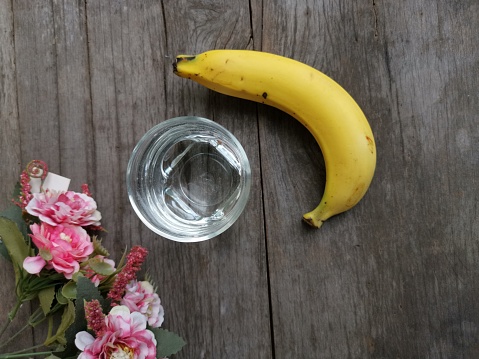 Banana and water drink on wood background